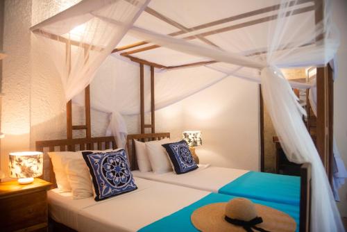 a bedroom with two beds with a hat on top at Villa Lala in Kiwengwa