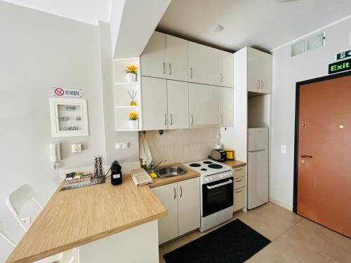 a kitchen with white cabinets and a sink and a stove at Sunlight studio in Athens