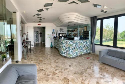 a living room with a couch and a bar at Hotel Tritone Rimini in Rimini
