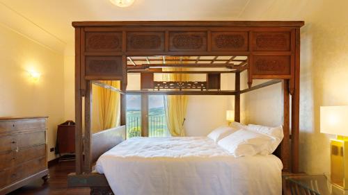 ein Schlafzimmer mit einem Himmelbett und einem Fenster in der Unterkunft Villa California 6, Emma Villas in Saludecio