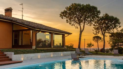 a villa with a swimming pool and a house at Villa California 6, Emma Villas in Saludecio