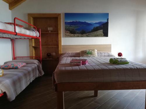 two beds in a room with two bunk beds at Casa Anna - Montemezzo in Bugiallo