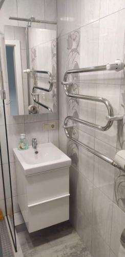 Baño blanco con lavabo y espejo en Butas miesto centre/ Apartment in the city center, en Šiauliai