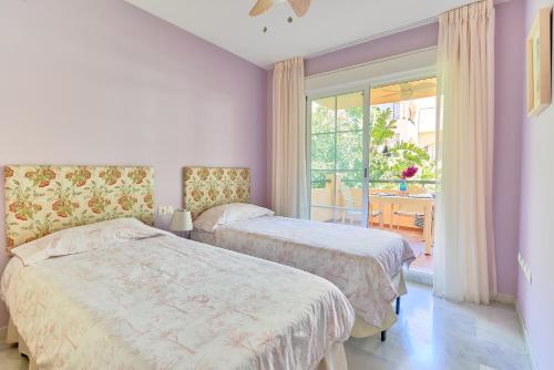 dwa łóżka w pokoju z oknem w obiekcie Beach & Golf Design Apartment Marbella w Marbelli