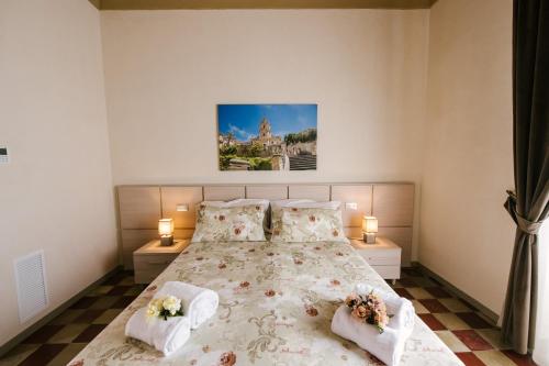 a bedroom with a large bed with two lamps at Le Camere dei Conti in Modica