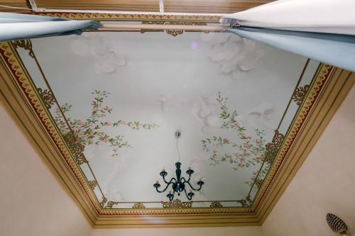 a ceiling in a room with a painting on the wall at Le Camere dei Conti in Modica
