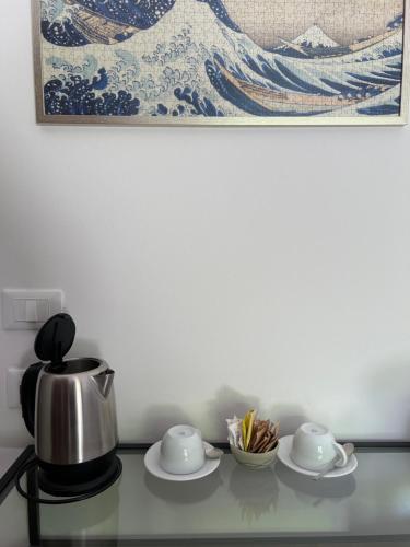 a table with a tea kettle and plates on it at Albergo Wellness Da Febo in Tramonti di Sotto