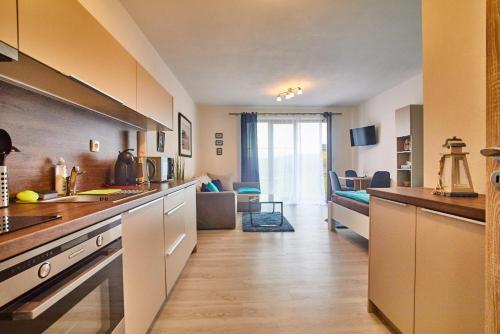 a kitchen with a counter and a living room at Apartmán Jasmin II in Frymburk