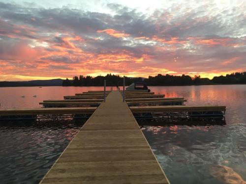 a dock on a lake with a sunset in the background at Apartmán Jasmin II in Frymburk