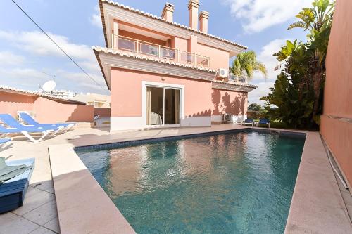 a villa with a swimming pool in front of a house at 812 Quinta Marina in Lagos