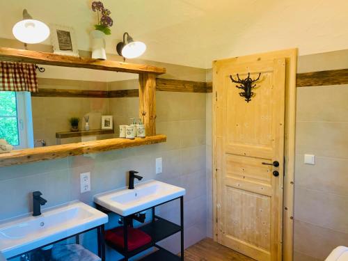 a bathroom with two sinks and a mirror at Bergheimat in Bad Goisern