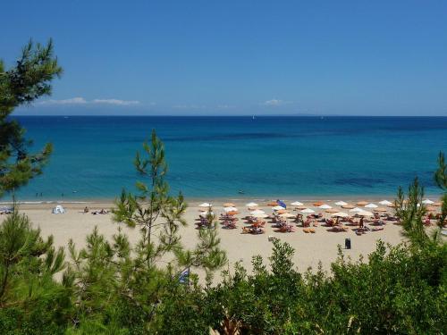 a beach with umbrellas and people on the beach at Villa Seagull in Skala Kefalonias