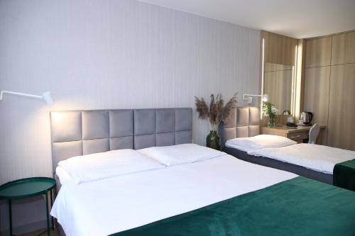 a bedroom with two beds with white sheets at Ośrodek Wypoczynkowy Pod Dębem in Wójtowice
