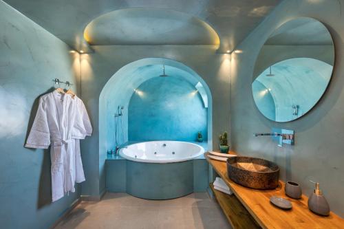 Alizea Villas & Suites في فيرا: حمام أزرق مع حوض ومغسلة