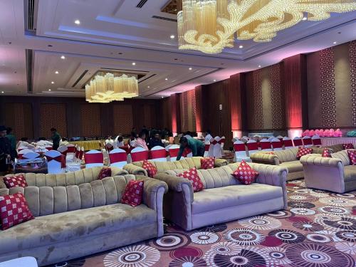 a banquet hall with couches and tables in a room at The Lalita Grand Mathura- Vrindavan in Mathura