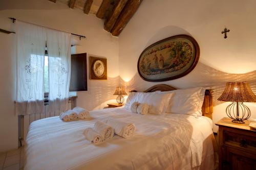 a bedroom with a large white bed with towels on it at Riserva Privata San Settimio in Arcevia
