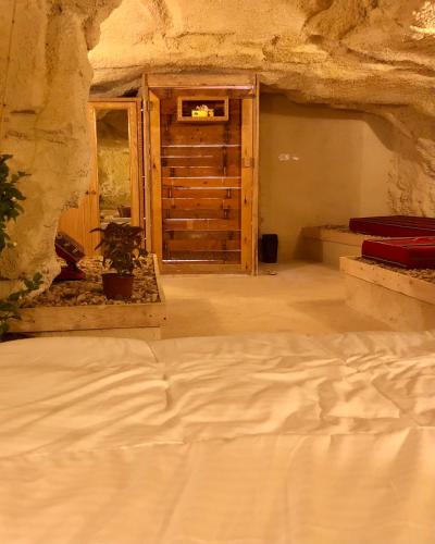 a bedroom with a bed in a stone room at 7 Caves Hotel in Al Jāyah