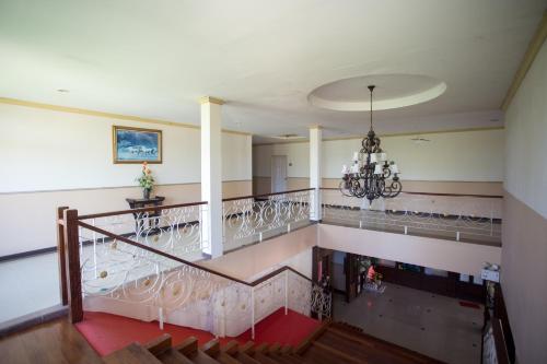 a staircase in a house with a chandelier at Phusuay Park View Hotel in Chaiyaphum
