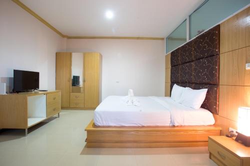 a bedroom with a large bed and a television at Phusuay Park View Hotel in Chaiyaphum