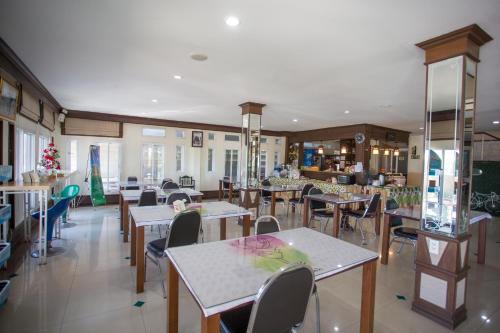 a restaurant with tables and chairs in a room at Phusuay Park View Hotel in Chaiyaphum