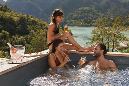 un gruppo di persone seduti in piscina con bevande di Albergo Wellness Da Febo a Tramonti di Sotto