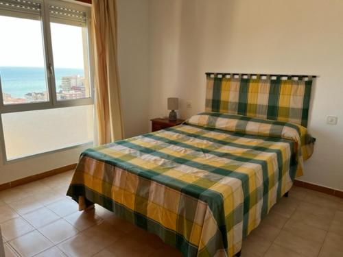 ein Schlafzimmer mit einem Bett und einem großen Fenster in der Unterkunft Santa Pola beach 2 habitaciones in Santa Pola