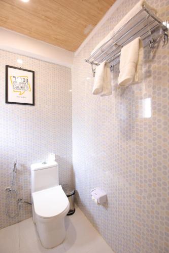 a bathroom with a toilet and towels on the wall at Amritara The Avadh in Badrīnāth