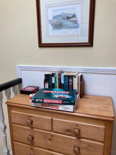 a stack of books sitting on top of a dresser at Fordbank House in Newton Stewart