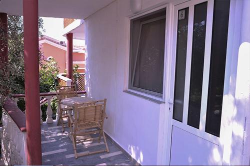 a porch with a door and a table and chairs at Vila Mila in Petrovac na Moru