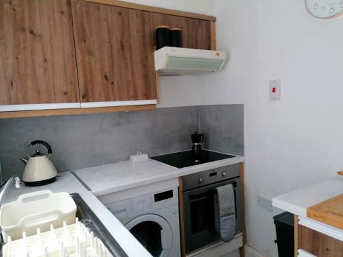 a kitchen with a sink and a washing machine at Unique city centre house with log burner & courtyard in Norwich