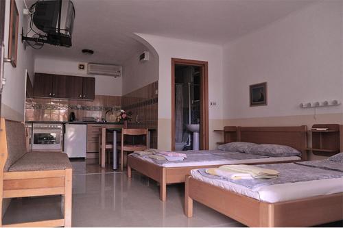a living room with two beds and a kitchen at Vila Mila in Petrovac na Moru