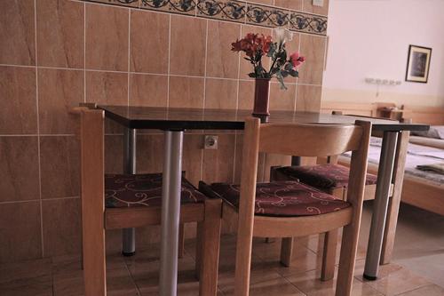 a dining room table with two chairs and a vase with flowers at Vila Mila in Petrovac na Moru