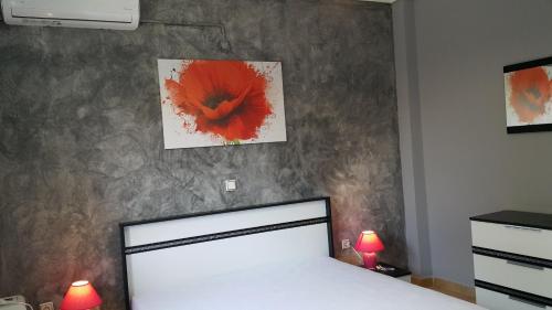 a bedroom with a bed with a red flower on the wall at HOPE HOUSE in Kavála