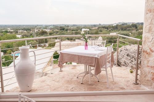 a white table and a vase on a balcony at La Terrazza Sulla Rupe Relais in Ostuni