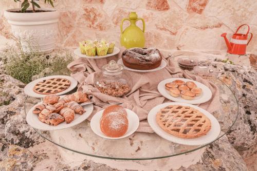 a table topped with plates of pastries and pies at La Terrazza Sulla Rupe Relais in Ostuni