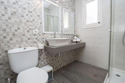 y baño con aseo, lavabo y ducha. en Casa Lluís by Sonne Villas en Cala Galdana