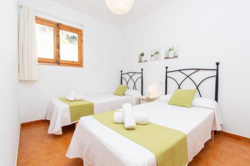 2 camas en una habitación con paredes blancas en Casa Lluís by Sonne Villas en Cala Galdana