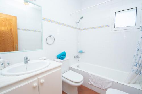 een witte badkamer met een wastafel en een toilet bij Villa Magnolia by Sonne Villas in Cala Galdana