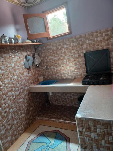 a kitchen with a laptop computer sitting on a counter at Dar rachid ouzoud in Azilal