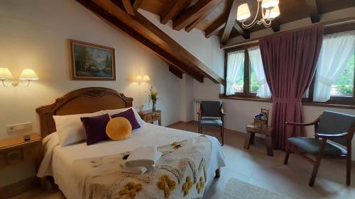 a bedroom with a bed and two chairs at Apartamentos El Haya in Cosgaya