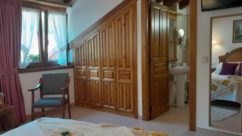 a bedroom with a bed and a chair and a sink at Apartamentos El Haya in Cosgaya