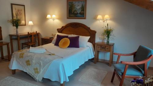 a bedroom with a bed with a yellow hat on it at Apartamentos El Haya in Cosgaya