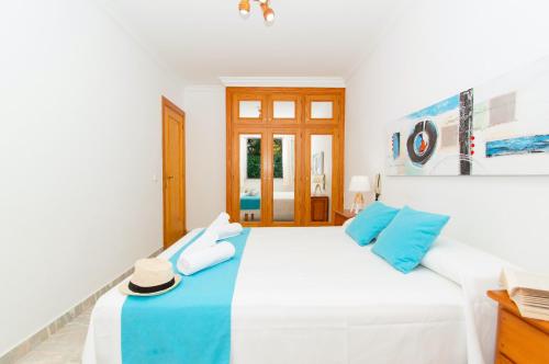 a bedroom with a large white bed with blue pillows at Casa Playa by Sonne Villas in Ferreries