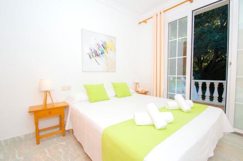 a white bedroom with a large bed and a window at Casa Playa by Sonne Villas in Ferreries