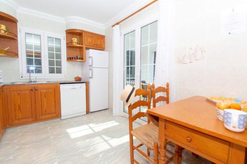 a kitchen with a wooden table and a dining room at Casa Playa by Sonne Villas in Ferreries
