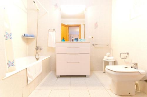 a white bathroom with a sink and a toilet at Casa Playa by Sonne Villas in Ferreries
