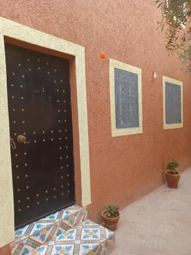 a door to a building with two potted plants at Dar rachid ouzoud in Azilal