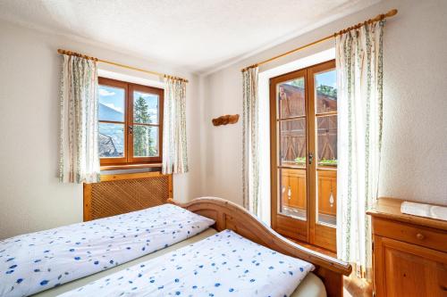 una camera con un letto e due finestre di Hof am Schloss Apartement Enzian a Montechiaro
