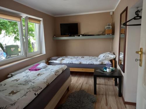 Habitación pequeña con 2 camas y ventana en Twoja Przestrzeń Noclegi Pokoje Mieszkanie Do Wynajęcia, en Nowy Sącz