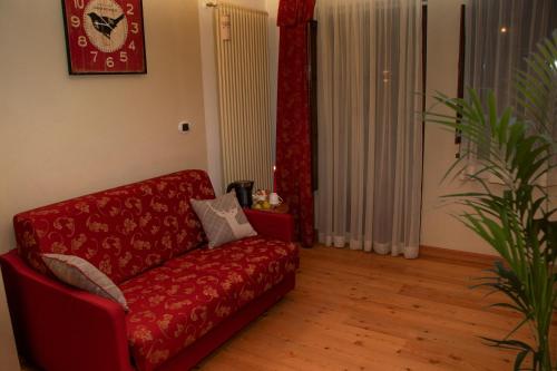 a living room with a red couch and a plant at Maison Cly in Chamois